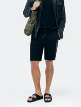 Bermuda de corte recto y estilo casual, confeccionada en tejido de algodón, con cintura elástica ajustable mediante cordón y bolsillos laterales.