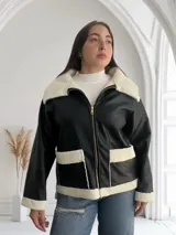 Campera de ecocuero negra con interior de corderito blanco, cierre frontal con cremallera y bolsillos laterales.