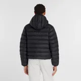 Campera puffer New Balance con capucha, cierre frontal bidireccional y puños elásticos. Diseño acolchado en color negro con logo de la marca estampado en el pecho.