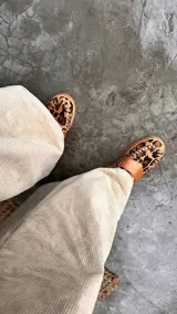 Mocasines dorados con aplique marrón en el empeine y detalle de costuras en la suela.