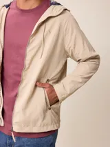 Campera de nylon con cierre frontal, capucha ajustable con cordones y forro interior a cuadros. Presenta bolsillos laterales y logo bordado en el pecho.