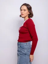 Cardigan de punto acanalado en color marrón, con escote en V, cierre frontal con botones a tono y mangas largas ajustadas.