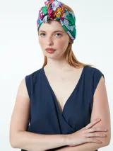 Vestido corto color beige, cruzado, sin mangas y ajustable con lazo lateral.