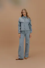 Jean de tiro alto con corte wide leg y pierna amplia, confeccionado en denim suave de tono claro.