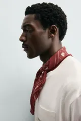 Pañuelo cuadrado (bandana) color bordó con estampado de corazones blancos y líneas curvas que forman un patrón de rejilla.