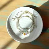 Set de tres pulseras ajustables con hilo encerado dorado y cuentas de piedras naturales, incluyendo amazonita, cuarzo rosa, ámbar, amatista, piedra luna y larimar.
