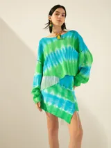 Minifalda de tejido de red teñida con técnica batik en tonos verde y celeste, con flecos y canutillos en un lateral.