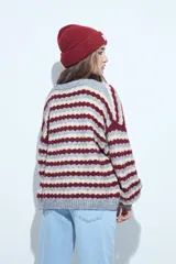 Cardigan de tejido de punto con diseño de rayas horizontales en tonos azul, gris y crema. Presenta escote en V, cierre frontal con botones grandes y mangas largas con puños anchos acanalados.