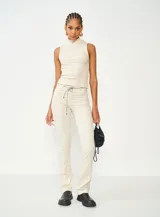 Blusa beige de cuello alto y corte ajustado, sin mangas y confeccionada en tejido de punto acanalado.