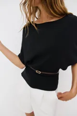 Top de punto color beige con cuello barco y mangas cortas anchas tipo murciélago. Cuenta con cintura entallada con ribete elástico y un cinturón fino de cuero sintético marrón con hebilla metálica dorada.
