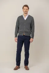 Cardigan de lana merino en color gris, con cuello en V, cierre frontal con botones y bolsillos delanteros.