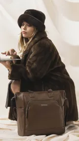 Cartera tipo tote de gran capacidad en color negro, confeccionada en símil cuero con textura granulada. Presenta doble asa corta, bolsillo frontal con cierre y herrajes metálicos. Incluye correa larga ajustable y desmontable.