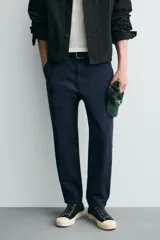 Pantalón de corte carrot fit confeccionado en tejido de algodón con estructura diagonal y efecto lavado. Presenta bolsillos frontales con bolsillo cerillero, bolsillos traseros de plastrón y cierre frontal con cremallera y botón.