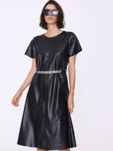 Vestido midi negro de cuero sintético con escote redondo, mangas cortas y cinturón de cadena dorada.