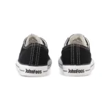 Zapatillas bajas de lona negra con cordones blancos y suela de goma blanca.