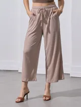 Pantalón negro de corte ancho, con pretina elastizada y lazo de ajuste.