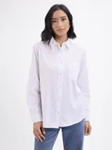 Camisa de corte clásico confeccionada en tela oxford color blanco, con cuello camisero, cierre frontal de botones, bolsillo aplicado en el pecho y puños abotonados.