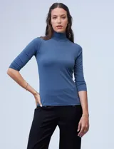 Polera negra de cuello alto y mangas 3/4, confeccionada en tejido elastizado.