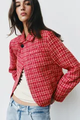 Blazer cruzado de tweed rojo con patrón texturizado en tonos blanco y negro, cuello con solapa, manga larga y cierre frontal con un botón.