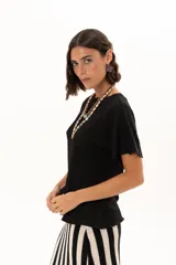 Blusa de textura arrugada en color negro, con cuello redondo y mangas cortas de corte holgado.