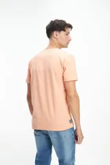 Remera color durazno con estampado azul en el frente con texto.