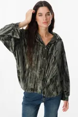 Camisa de manga larga confeccionada en terciopelo con acabado arrugado. Presenta cuello clásico, cierre frontal con botones y puños abotonados.