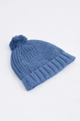Gorro de lana tejido en punto trenzado color azul con pompón en la parte superior.