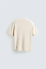 Camiseta de punto de algodón con textura perlada, corte regular fit, cuello redondo y manga corta con terminaciones en rib.