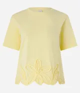 Blusa amarilla de mangas cortas con cuello redondo y bajo con flores bordadas.