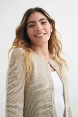 Cardigan verde esmeralda de tejido de punto calado, con mangas 3/4 y corte evasé. Presenta cuello redondo con abertura en forma de gota y cierre con un único botón.