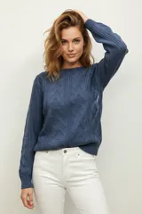 Sweater de punto acrílico azul, con diseño de punto trenzado en el frente y mangas, cuello redondo y calce holgado.