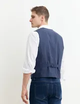 Chaleco azul marino con cierre de botones, bolsillos frontales y corte clásico.