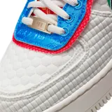 Zapatillas Nike Air Force 1 Shadow color blanco con detalles en rojo, azul y verde. Presentan un diseño deconstruido con superposiciones y detalles a cuadros.