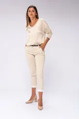 Pantalón de vestir beige con sutiles rayas verticales, corte recto, tiro medio y terminación cropped con dobladillo.