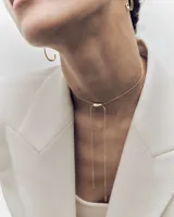 Collar deslizante de oro PDPAOLA, diseño minimalista con cadena fina y cierre ajustable con detalle ovalado, del cual caen dos tiras finas con terminales en punta.