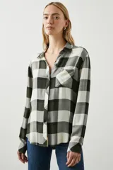 Camisa de manga larga con estampado tartán en tonos verde, gris y blanco, con cuello clásico, cierre frontal con botones, bolsillo en el pecho y corte regular.