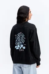 Buzo de algodón con efecto acid wash y diseño vintage. Presenta cuello redondo, mangas largas con puños acanalados, bolsillo frontal tipo canguro y estampa gráfica pequeña en el pecho.