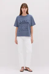 Remera de manga corta color azul con cuello redondo, de corte holgado y diseño estampado con la frase "Girl Affirmations" y frases motivacionales en el frente.
