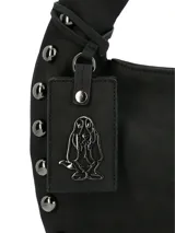Cartera tipo hobo de la marca Hush Puppies, color negro, con diseño de asa única integrada y detalle de tachas metálicas en los laterales y la base. Incluye un colgante decorativo con el logo de la marca.