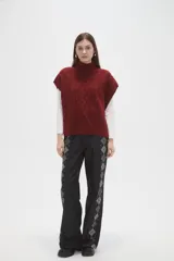 Chaleco de punto con diseño de ochos y cuello polera, de calce holgado y sin mangas.