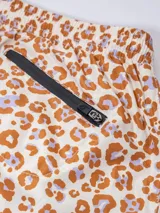 Short de baño con estampado animal print en tonos marrón y lila, con cintura elástica y logo bordado en la pierna.
