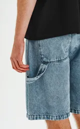 Bermuda de denim estilo carpintero, color celeste claro con efecto acid wash/desgastado. Presenta un calce oversize, bolsillos delanteros y un bolsillo utilitario lateral.