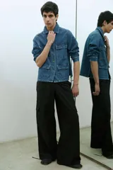 Pantalón estilo cargo color negro, confeccionado en tela avión, con cintura elastizada ajustable mediante cordón y puños regulables en los tobillos con tiras para ajustar.