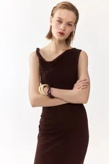 Vestido midi marrón sin mangas, de punto suave, con escote drapeado y cuentas decorativas irregulares en el tirante derecho. Presenta frunces en el lateral con efecto drapeado.