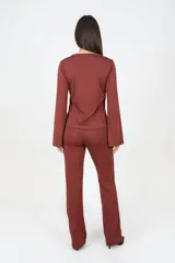 Conjunto de pantalón y blusa bordó. El pantalón es de corte recto y la blusa tiene cuello drapeado y mangas acampanadas.
