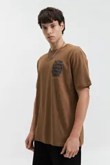 Remera marrón de manga corta con cuello redondo y estampado con la frase "Slow Down You're Doing Fine" en el pecho.