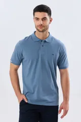 Remera polo de piqué de algodón color azul, de manga corta, con cuello camisero, cierre frontal de dos botones y pequeño logo bordado en el pecho.