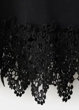 Camiseta negra de algodón con cuello redondo, mangas cortas y detalle de encaje en el borde inferior.