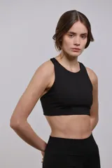 Top deportivo de sujeción media con escote redondo, diseño al cuerpo y espalda abierta. Cuenta con elástico interno en la cintura para mayor seguridad.