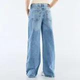 Pantalón jean de tiro bajo, color azul con lavado medio, corte ancho y recto, con cordón ajustable en la cintura.